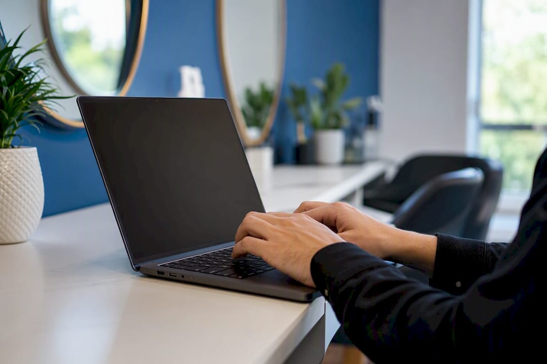 Hands typing code on laptop keyboard