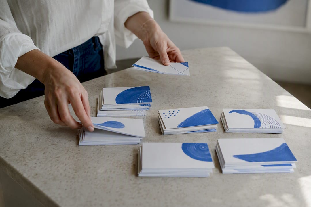 Hands organizing company list cards on table