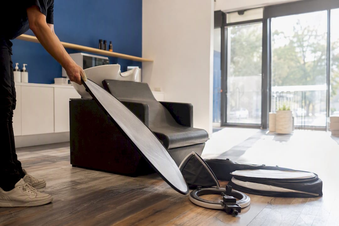 Stylist adjusting light reflector in salon