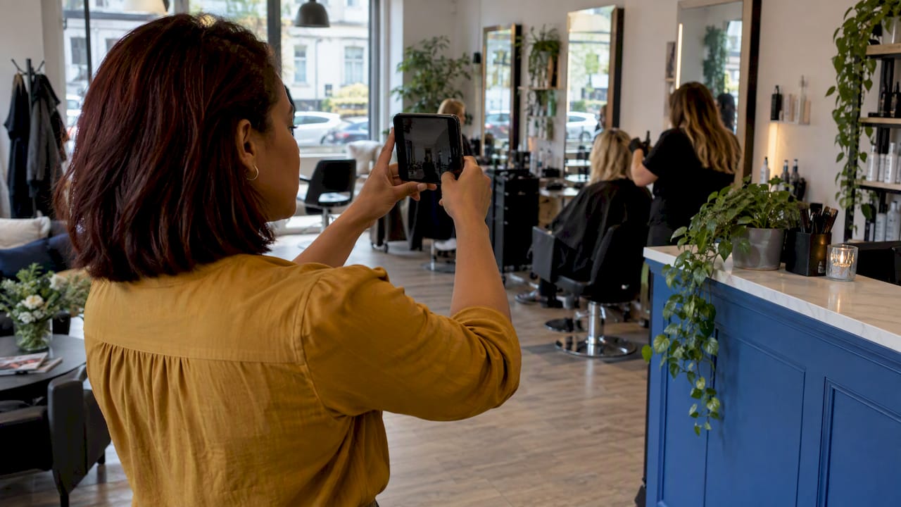 Salon owner photographing a branch interior