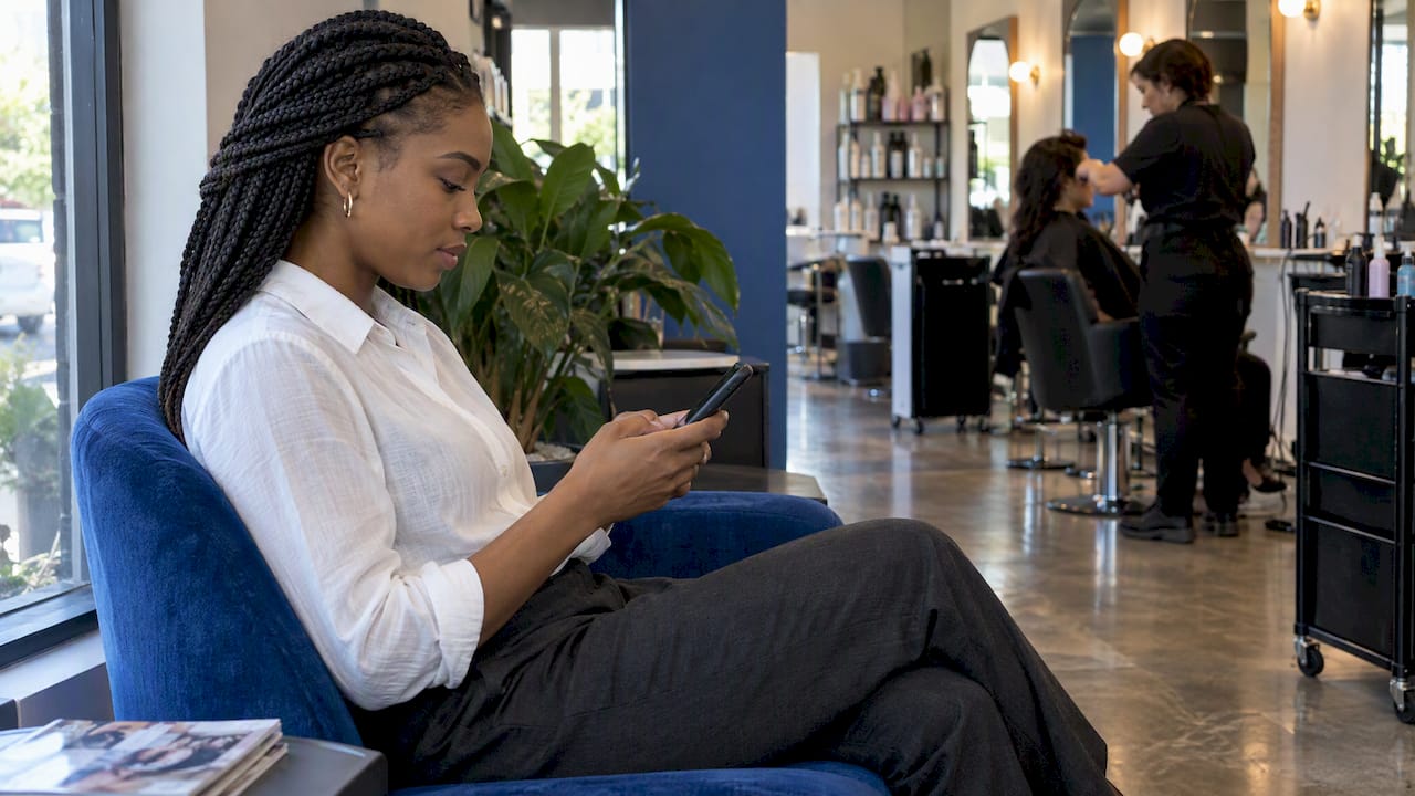 Salon client booking an appointment on her phone